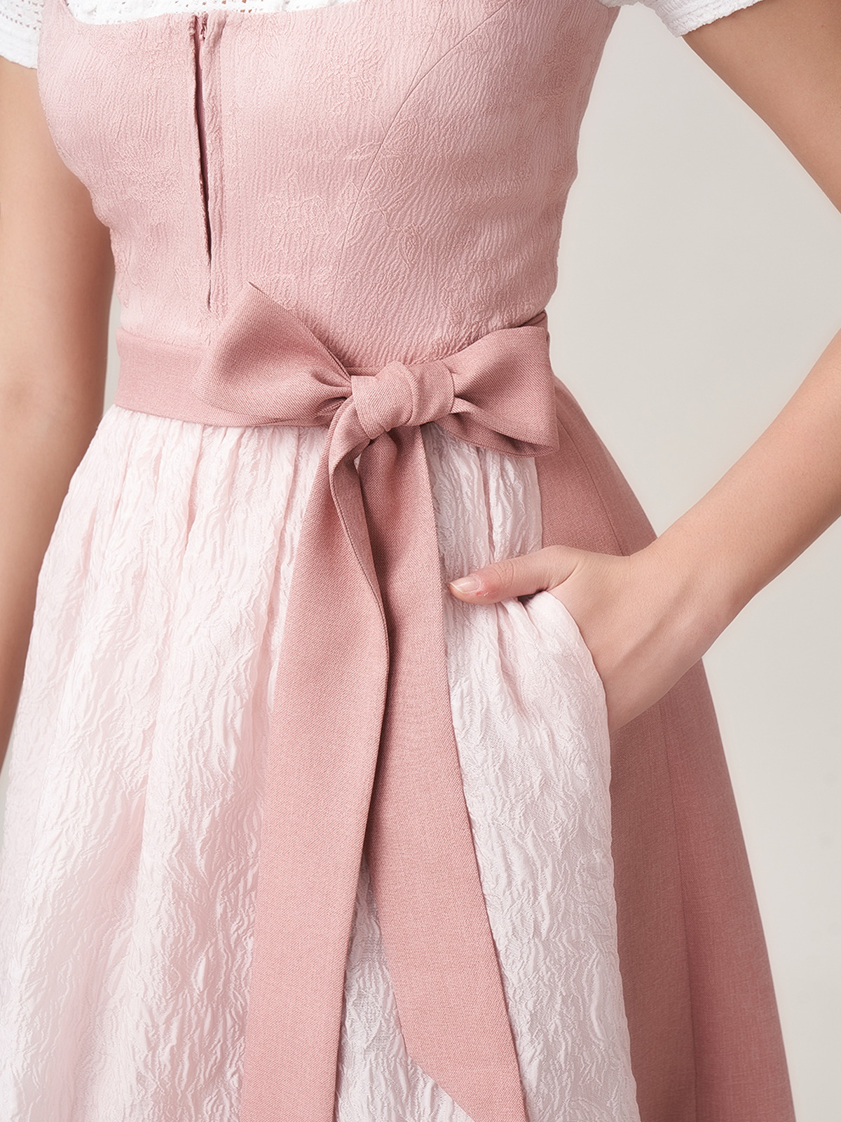 Ein elegantes rotes Dirndl mit Spitzenbluse und schwarzer Schürze